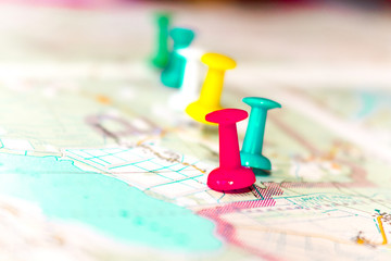 Travel destination points on a map indicated with colorful thumbtacks and shallow depth of field...