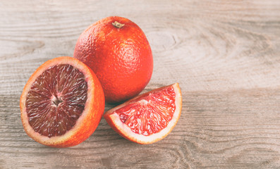 Fresh sliced bloody oranges on a wooden background