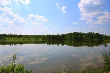 Red and orange autumn foliage reflected in the clear water of the lake. Concept of recreational tourism. Park fantastic beauty. Shining sunny day