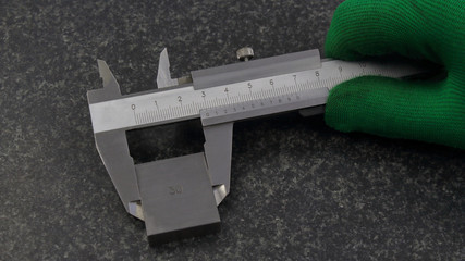 Calipers in hand, measuring rectangular parts