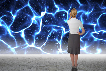 Thinking businesswoman against glowing blue lights over desert