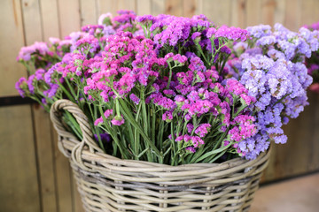 In a wicker basket variety of limonium sinuatum or statice salem flowers in pink, lilac, violet colors in the garden shop.