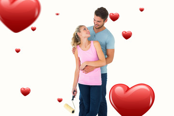 Young couple painting with roller against hearts