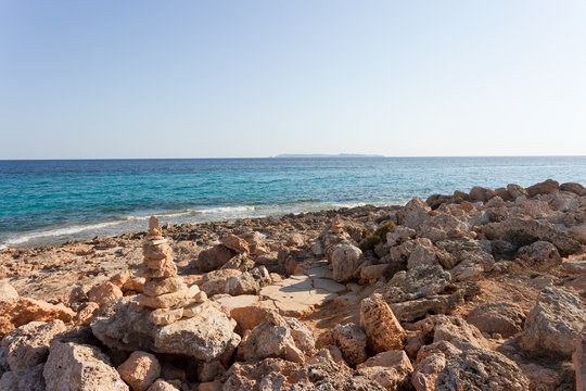 Cap de Ses Salines, Mallorca - The famous orange pebble stone at the beach of Ses Salines