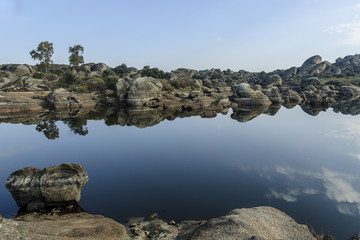 scenery with reflexes in the water of the park and natural monument of the Barruecos in Malpartida...