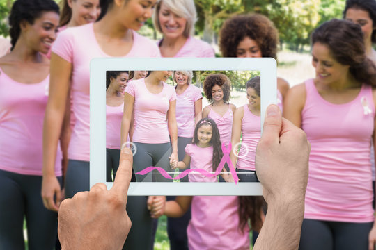 Composite image of hand holding device showing photograph of breast cancer activists