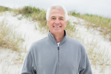 Smiling handsome casual senior man at beach