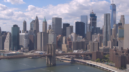 Fototapeta na wymiar AERIAL: Brooklyn and Manhattan Bridges over East River against New York skyline