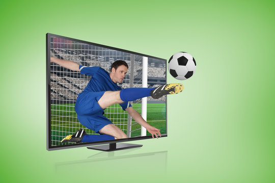 Composite image of football player in blue kicking ball through tv screen against green vignette