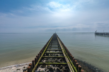 Obraz premium Old Broken Boardwalk Into The North Sea At The Harbour Of Vlissingen Province Zeeland