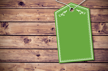 Elegant green tag against wooden planks background