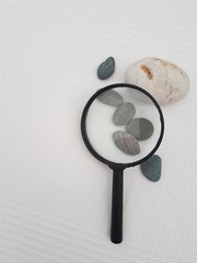  Magnifying glass, gray stones background