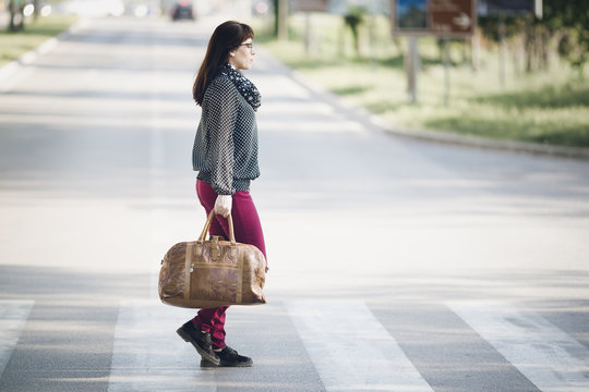 The woman crosses a pedestrian crossing