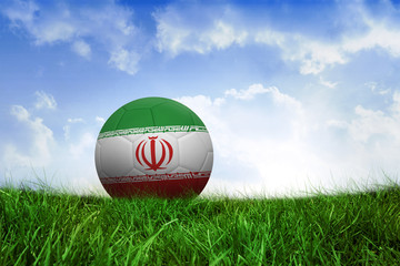Football in iran colours on field of grass under blue sky