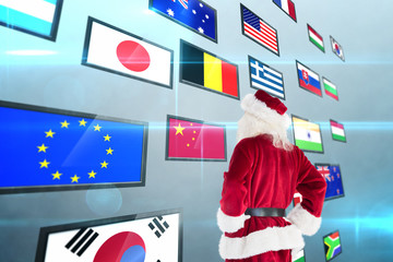 Santa looks away from the camera against screen collage showing international flags