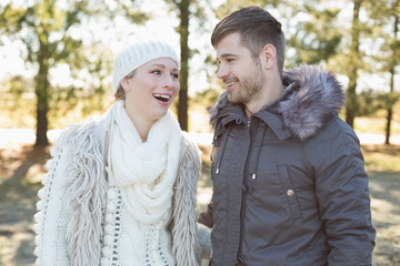 Fototapeta premium Cheerful couple in winter clothing in the woods
