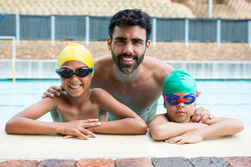 Father and kids smiling in the pool