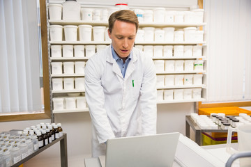 Focused pharmacist using his laptop