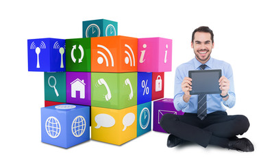 Smiling businessman showing his digital tablet against app cube