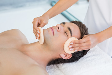 Fototapeta na wymiar Man receiving facial massage at spa center
