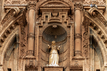 Damaged statue on the facade of the Temple of the Company of Jesus in Cusco, Peru