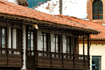 Fototapeta na wymiar Wrought wood balconies and tiles eaves in front of the main square of Cusco (Peru)