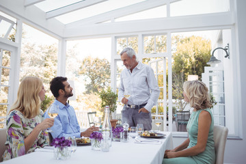 Group of friends interacting with each other while having meal together