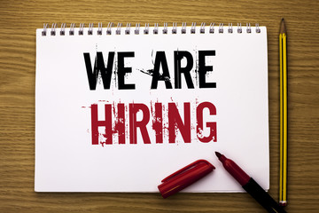 Writing note showing  We Are Hiring. Business photo showcasing Talent Hunting Job Position Wanted Workforce HR Recruitment written on Notebook Book on the wooden background Marker and Pencil.