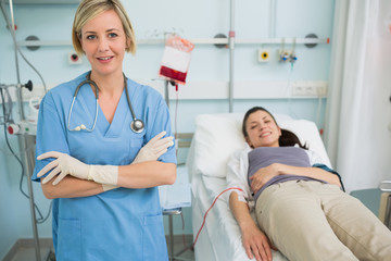 Obraz premium Nurse standing next to a female transfused patient