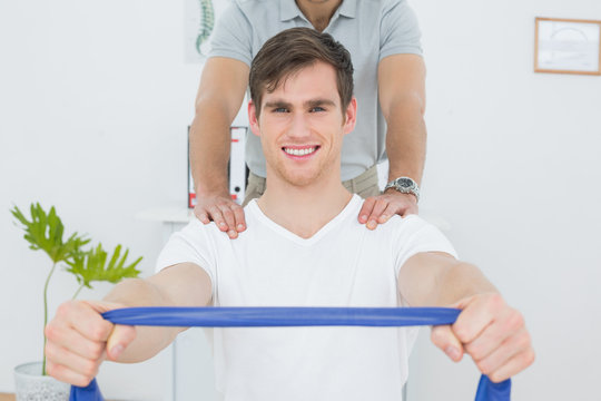 Man doing exercises with the help of therapist in office