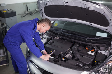 Concentrated mechanic repairing a car