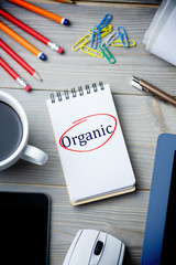 The word organic against notepad on desk