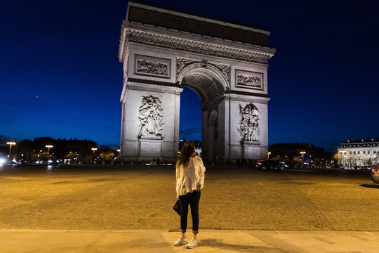 A Woman At Arc De Triomphe In Paris, France At Night