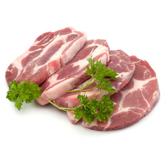 Raw pork neck chop meat with parsley herb leaves garnish isolated on white background cutout