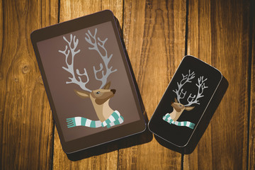 hipster reindeer against tablet and smartphone on desk