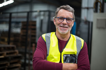 Portrait of male factory worker standing with arms crossed - Powered by Adobe