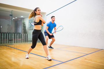 Couple play some squash together - 202560054