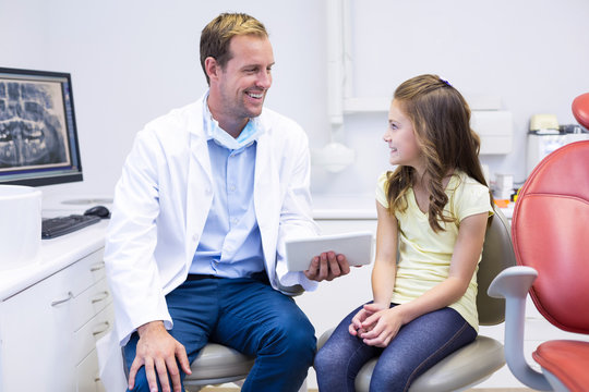 Dentist interacting with young patient in dental clinic