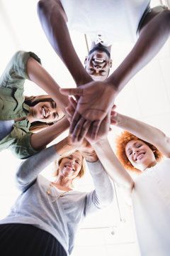 Directly Below Portrait Of Business People Stacking Hands