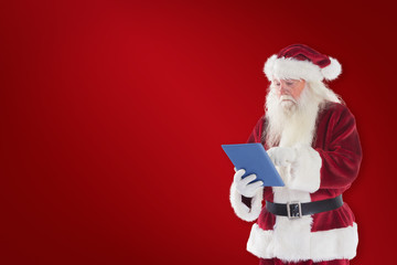 Santa uses a tablet PC against red background