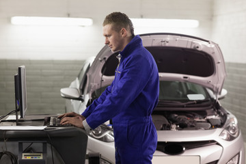 Concentrated mechanic looking at a computer