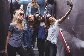 Female friends taking selfie while standing on steps