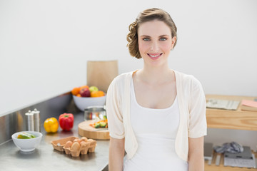 Obraz na płótnie Canvas Attractive brunette woman posing in her kitchen