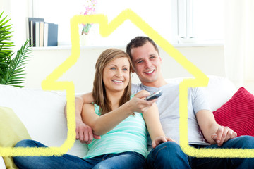 Charismatic man embracing his girlfriend while watching tv  against house outline