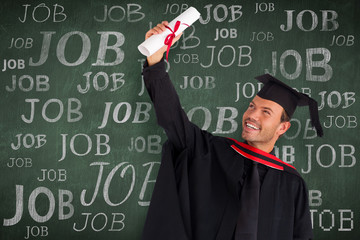 Happy attractive boy celebrating his graduation  against green chalkboard