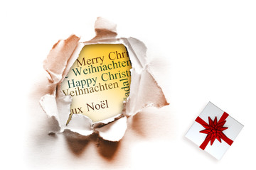 Christmas present with bow against circle hole in paper