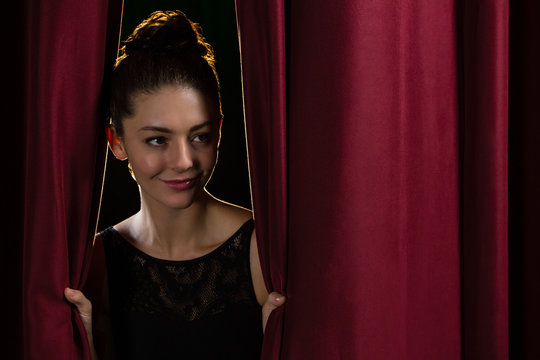 Ballet Dancer Peeking Through A Stage Curtain