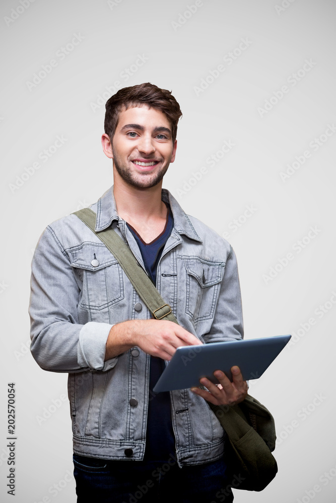 Poster student using tablet in library against grey vignette