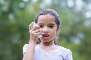 Little girl using his inhaler