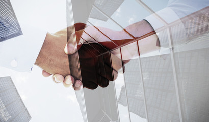 Close-up shot of a handshake in office against skyscraper